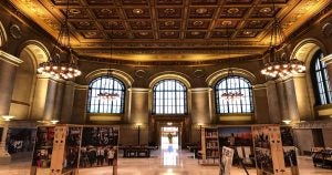The inside of St Louis Public Library with high ceilings, chandeliers, high arch windows, and an art display below. | Ellisville, MO