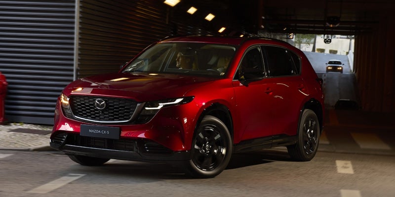 Red Mazda CX-5 SUV driving through a tunnel with a driver visible inside.