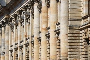 The side of a tall building with old, very detailed architecture.