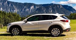 White Mazda CX-5 parked with mountains with greenery and trees in the background. | Mazda dealer in Ellisville, MO