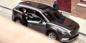 A man and woman getting into a charcoal gray 2019 CX-9 Mazda | Ellisville, MO