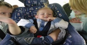 Three children riding in the back seat of a vehicle | Ellisville, MO