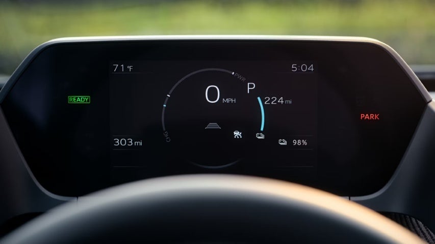 Digital dashboard of the Toyota bZ4X showing speed, range, battery level, and temperature.
