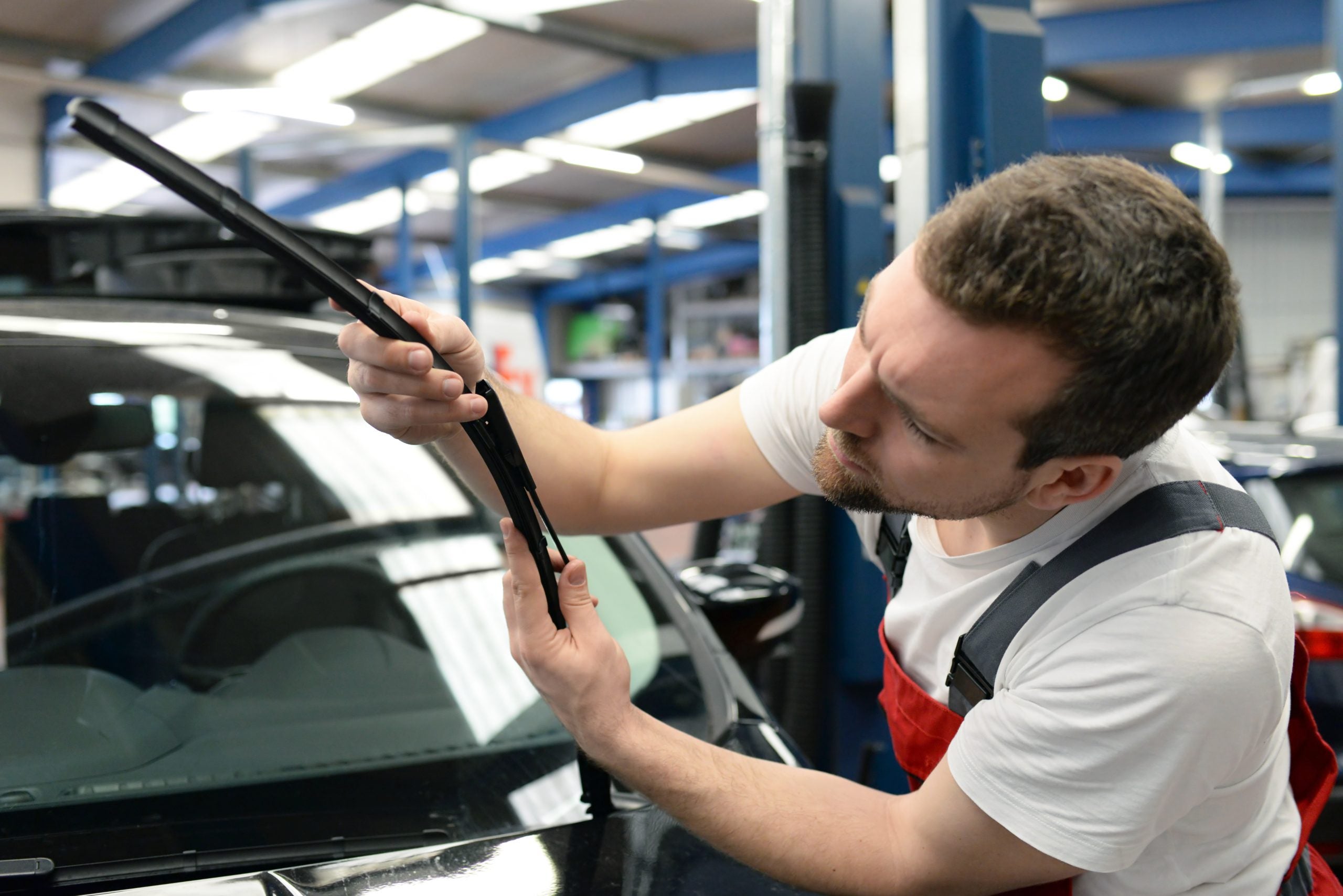 Mechanic replacing windshield wipers.
