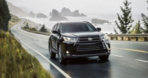 Toyota Highlander driving along a coastline road.