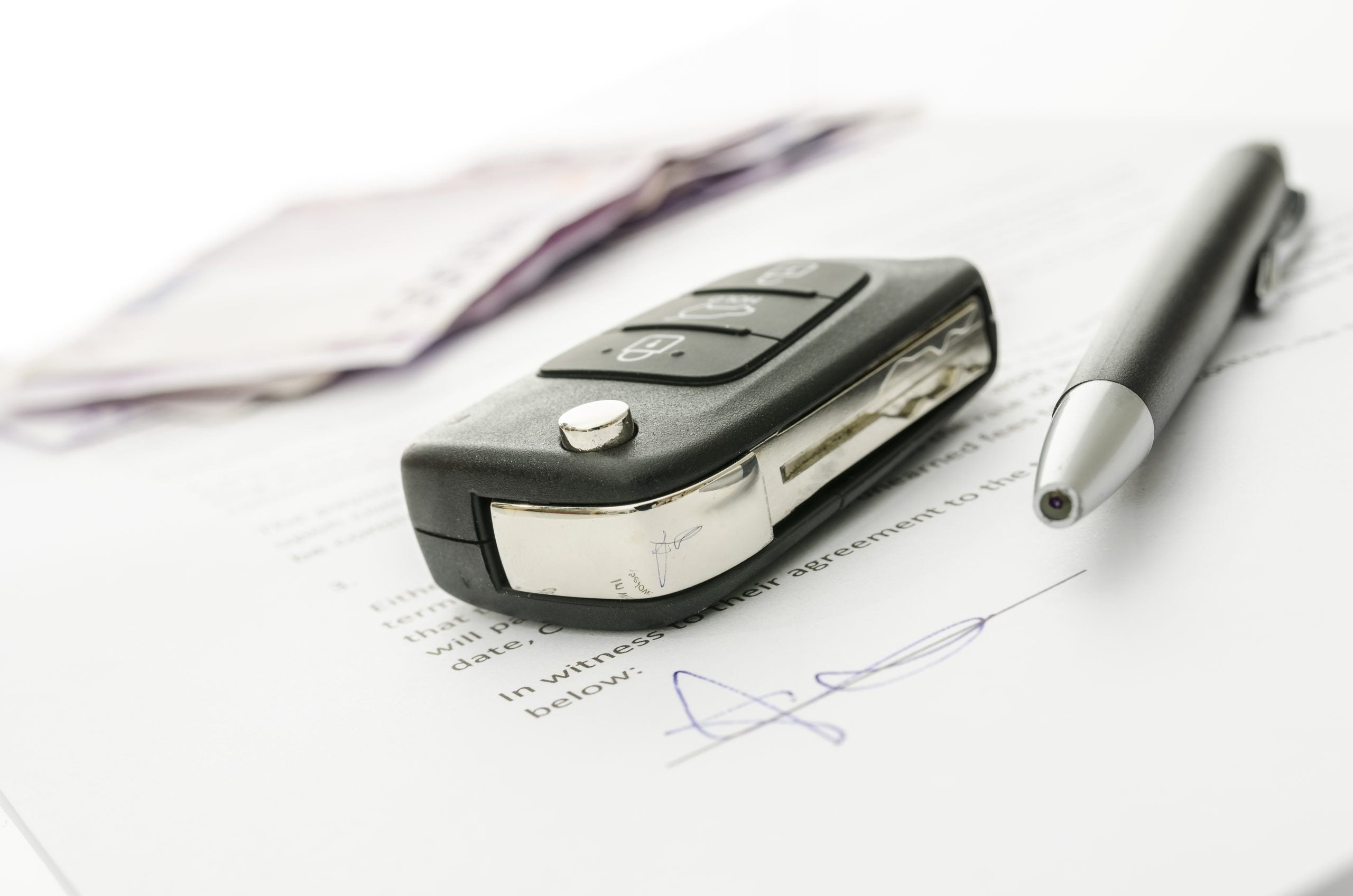 Black,Car,Key,And,Money,On,A,Signed,Contract,Of