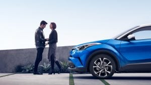 A couple standing outside their 2019 Toyota CH-R.