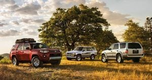 A collection of 3 2020 Toyota 4Runners parked in a grassy field.