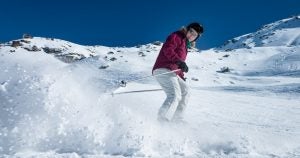 A lady named Pip skiing in the mountains.