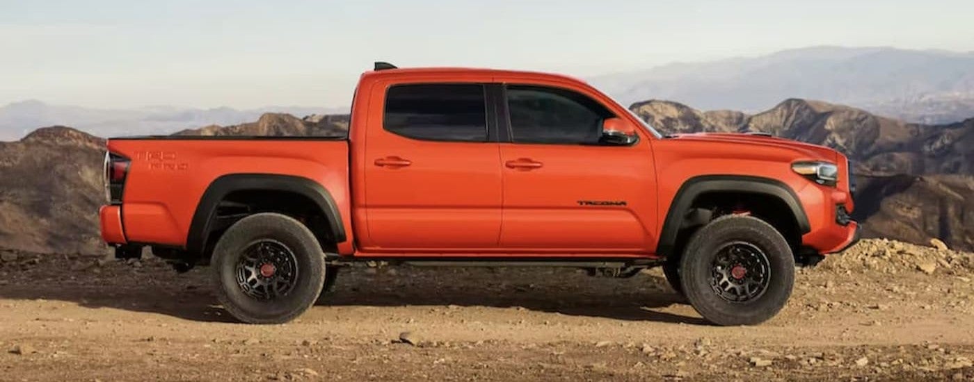 An orange 2023 Toyota Tacoma parked offroad.