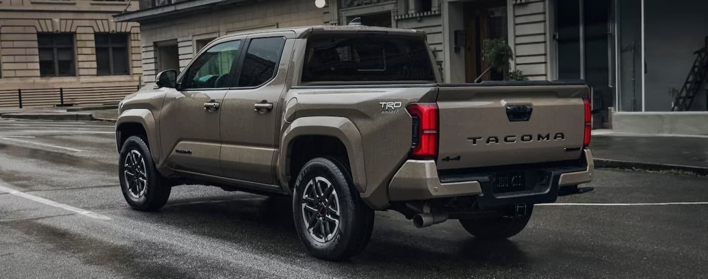 A brown 2026 Toyota Tacoma driving in a city.