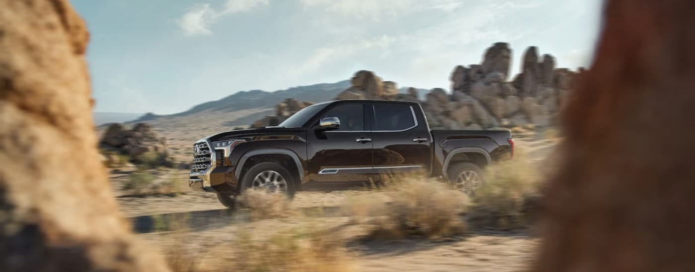 Black 2024 Toyota Tundra driving offroad.