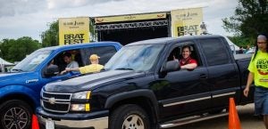 Take Your Brat to Work Day. People in their vehicle pick up brats.