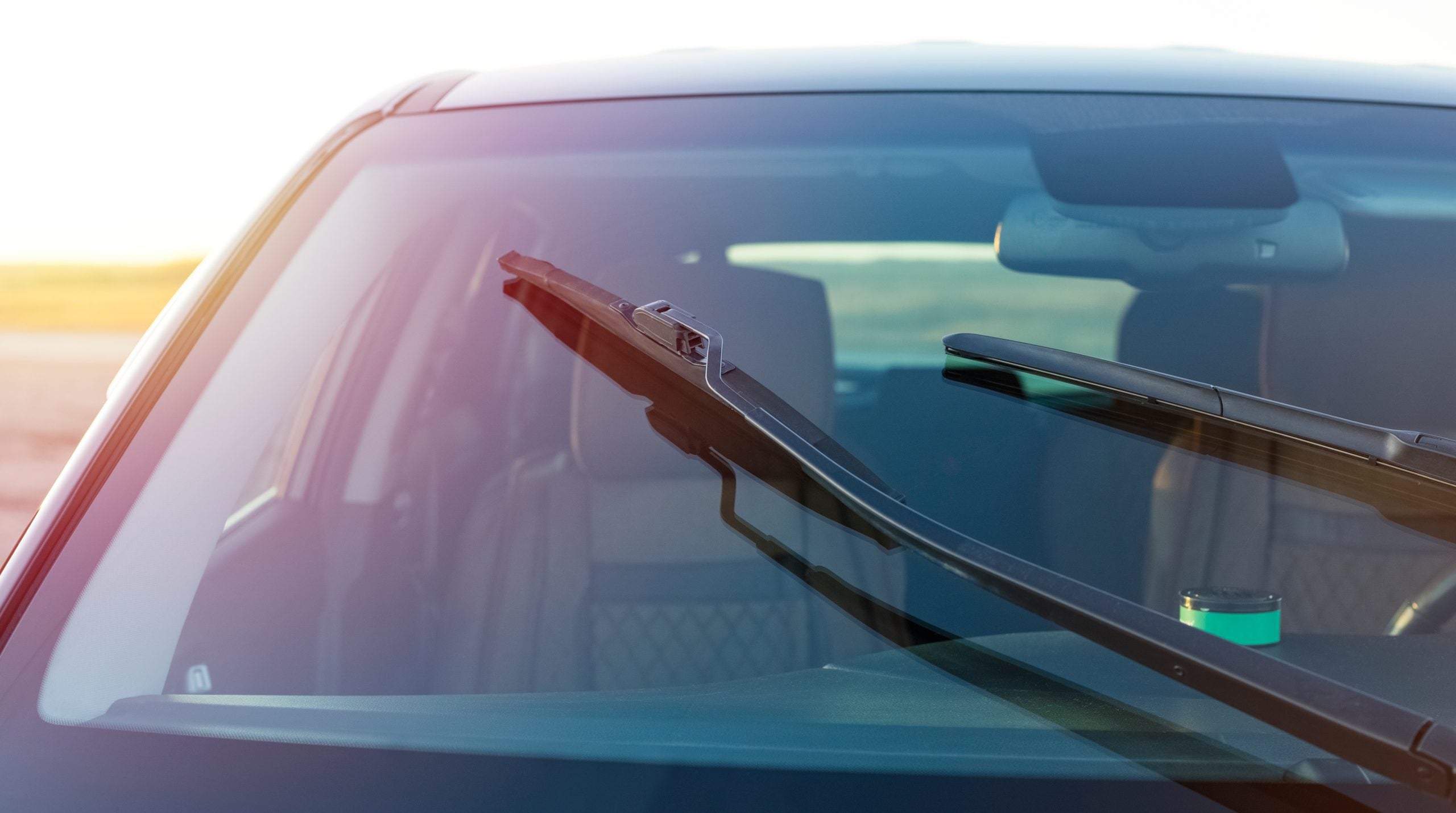Windshield wipers active on the front of a car.