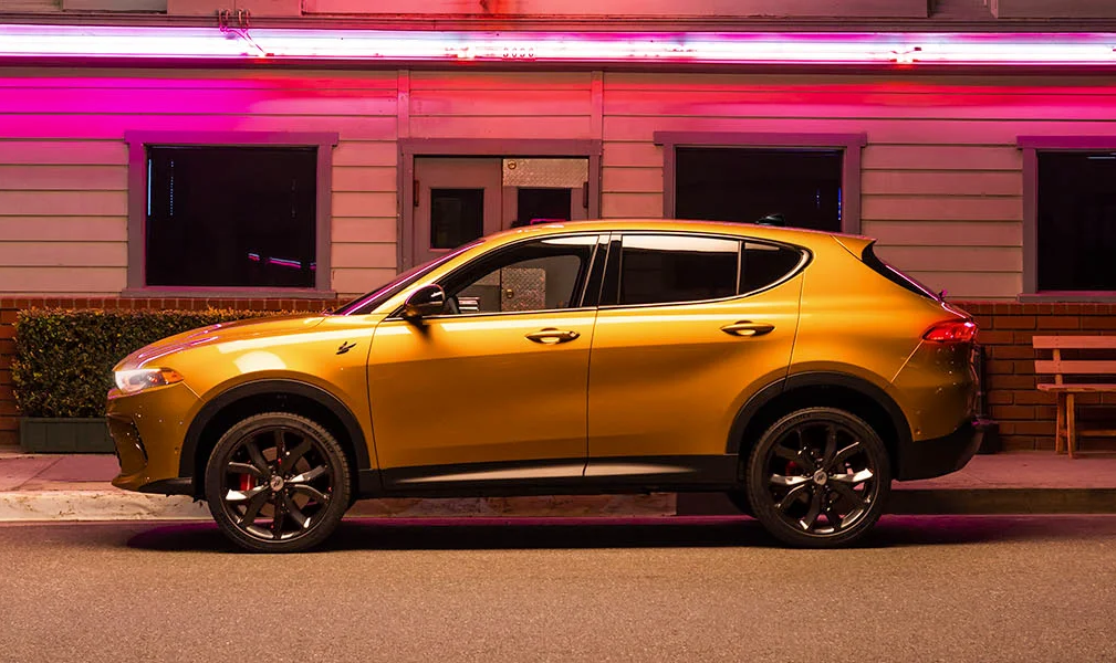 The 2024 Dodge Hornet speeding down a colorful downtown city street