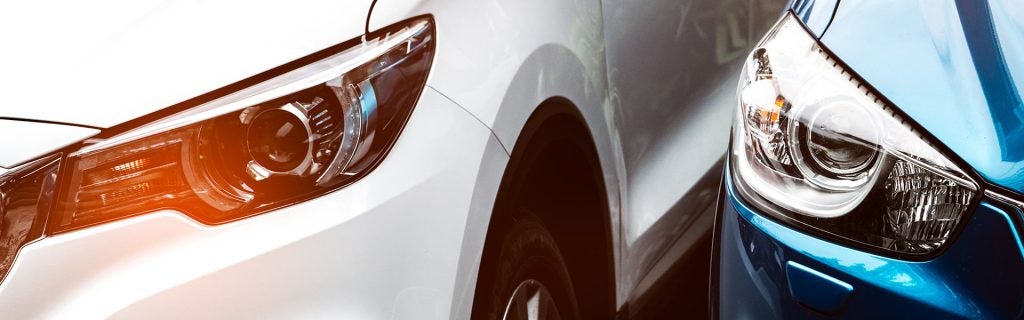 Close-up of two cars parked side by side.