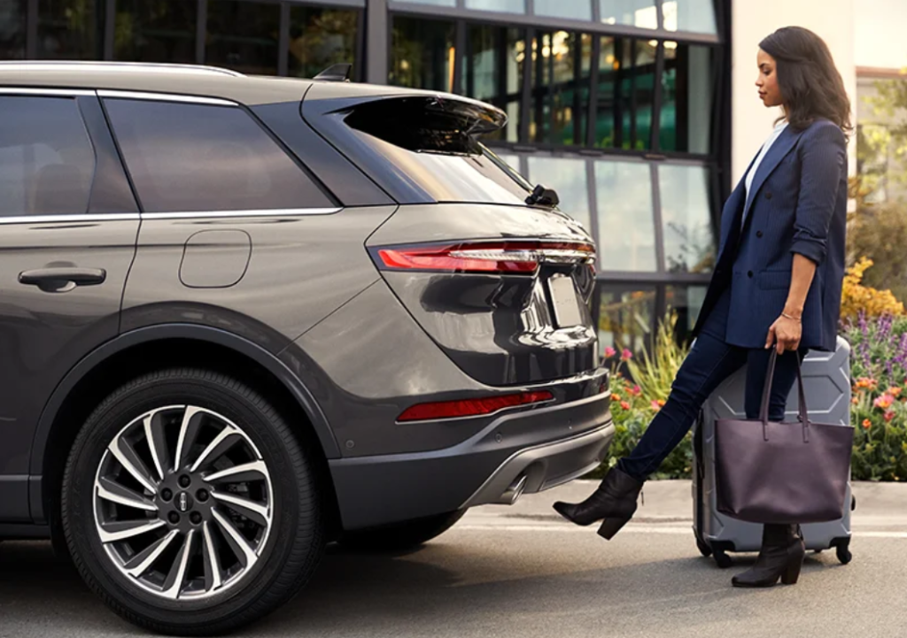A woman opening the trunk of her 2023 Lincoln Corsair by activating the foot-lift gate.