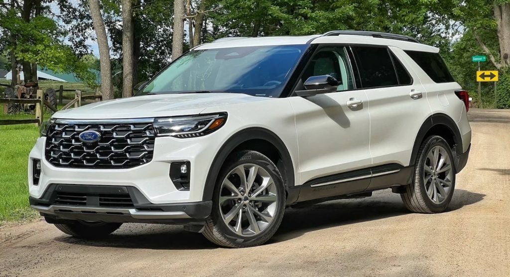 A white 2025 Ford Explorer is parked alongside a dirt road, showcasing it's impeccable style and off-road capability. Find your new Ford Explorer at Johnson City Ford near Bristol.