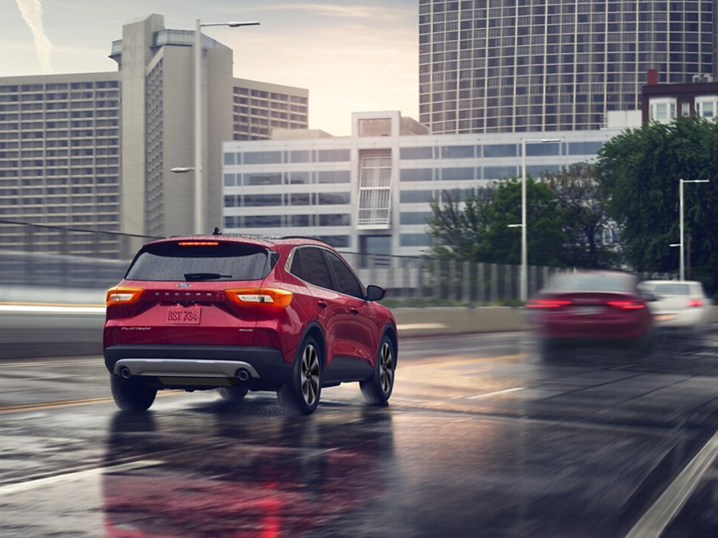 The new red 2025 Ford Escape drives down a rainy road, making this SUV perfect for any kind of weather. Shop for your new Ford Escape at Johnson City Ford today!