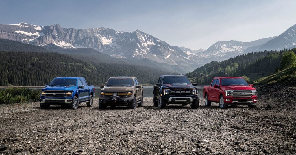 A lineup of new Ford trucks sits parked with a mountain range behind them. Shop for your new 2026 Ford at Johnson City Ford.