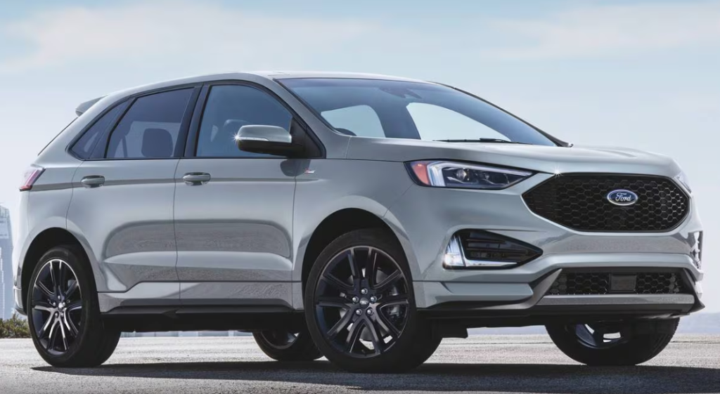 A Ford Edge sits parked with a cityscape behind it.