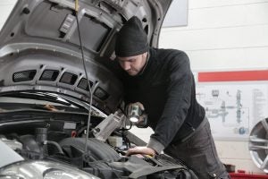 Person Looking Inside Hood of Car