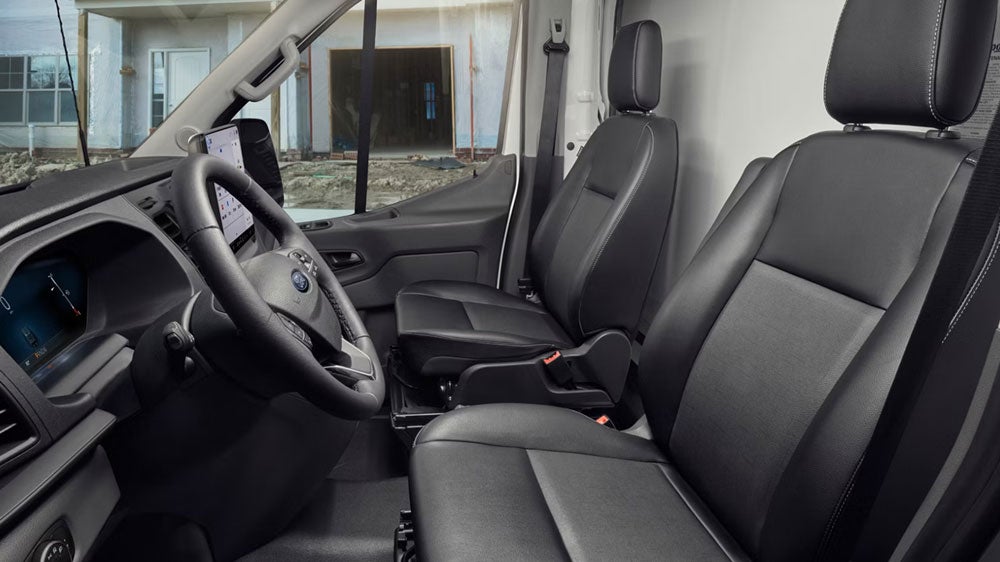 Front interior cabin of the 2027 Ford Transit featuring ergonomic bucket seating and the center SYNC 4 display.