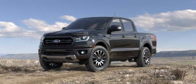 Absolute Black color 2019 Ford Ranger exterior front fascia and drivers side parked in wilderness