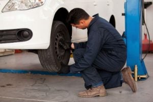 mechanic rotating tires in shop