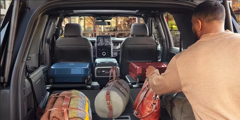 An individual loading luggage in to the back of a 2024 Ford Explorer near Wellington, OH.

