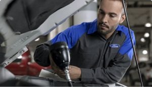 A tech working on a Ford vehicle. 
