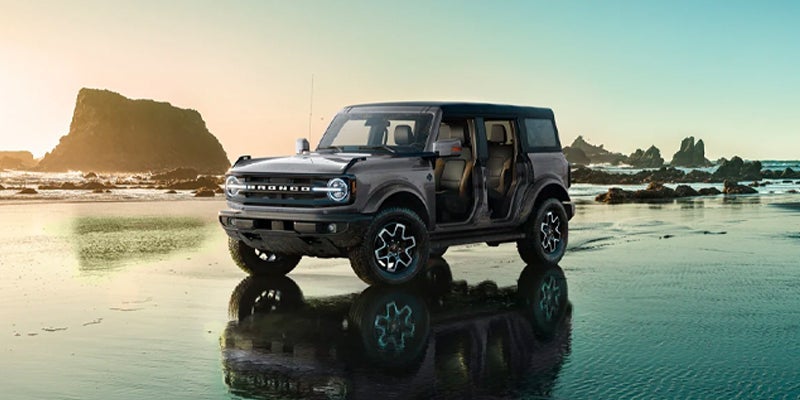 2023 Ford Bronco parked on the beach with sunset behind