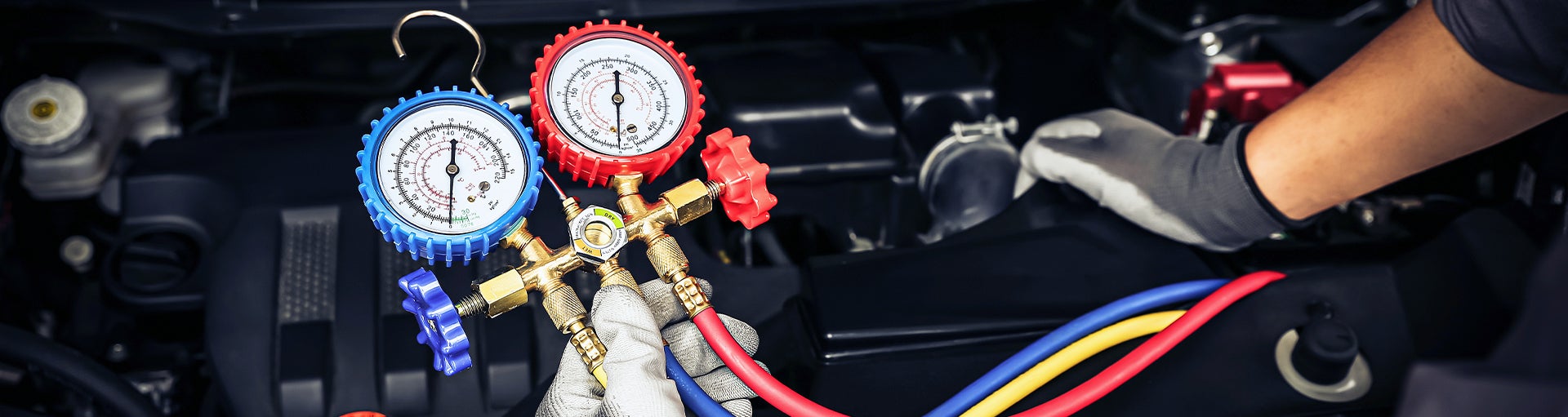 Close-up of a service technician working on a vehicle's engine.