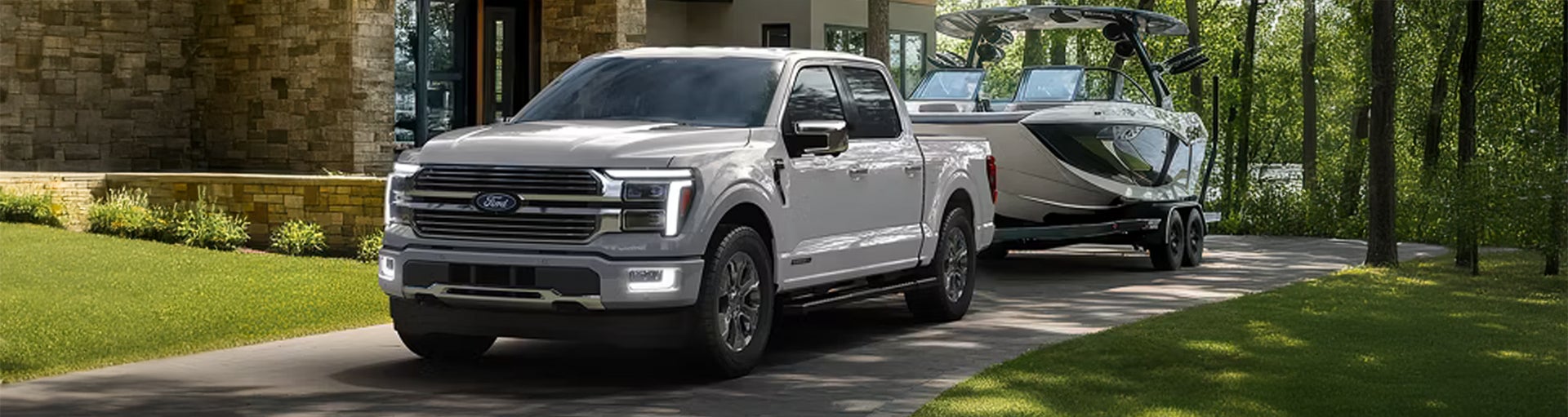 A silver Ford F-150 with a boat attached.