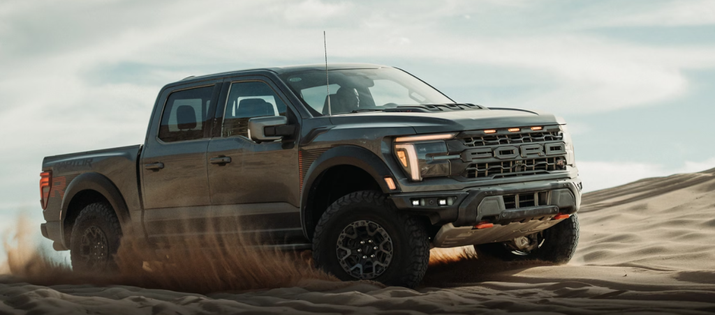 A new 2025 Ford F-150 off-roads on beach sand.