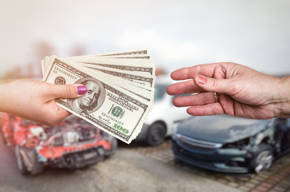 A hand transfers money to another person, with a car in the background, highlighting no dealer fees at Sawgrass Ford.