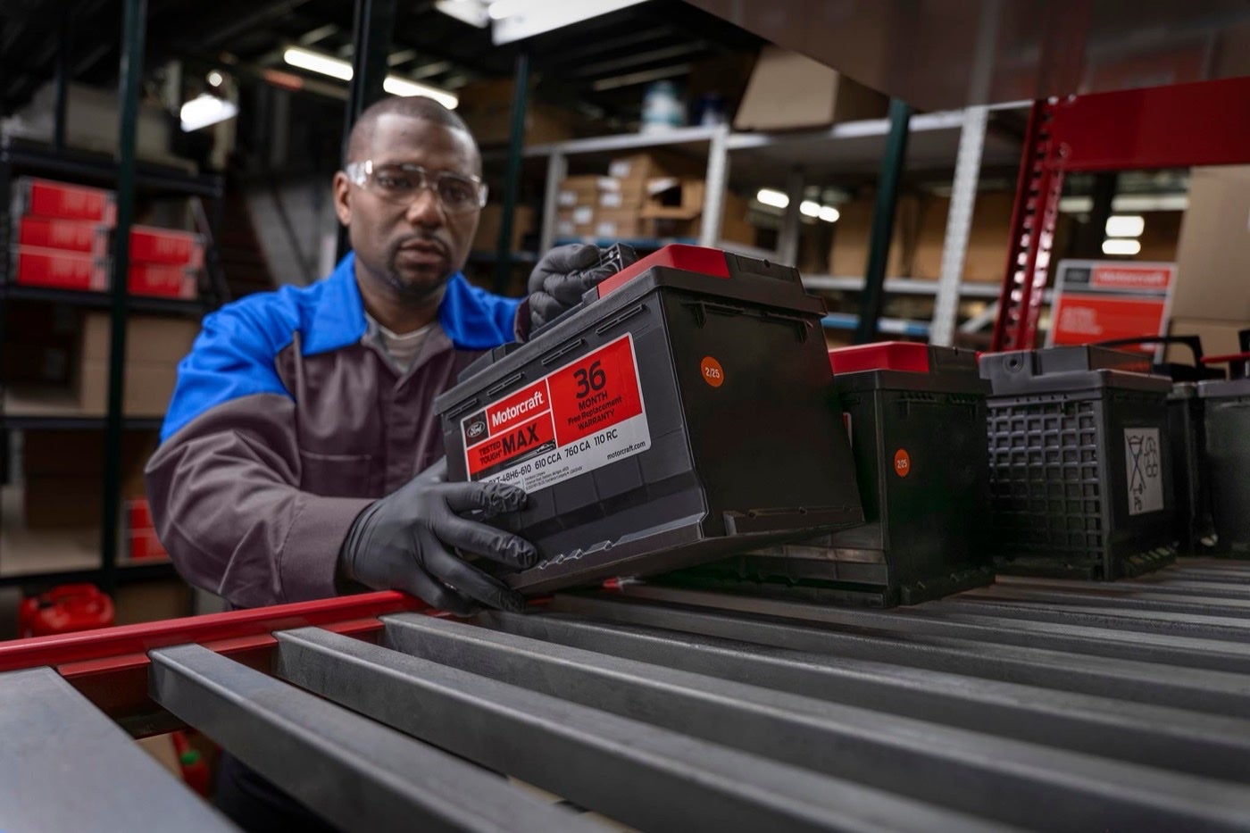 Ford Service technician pulling a new battery from the shelf
