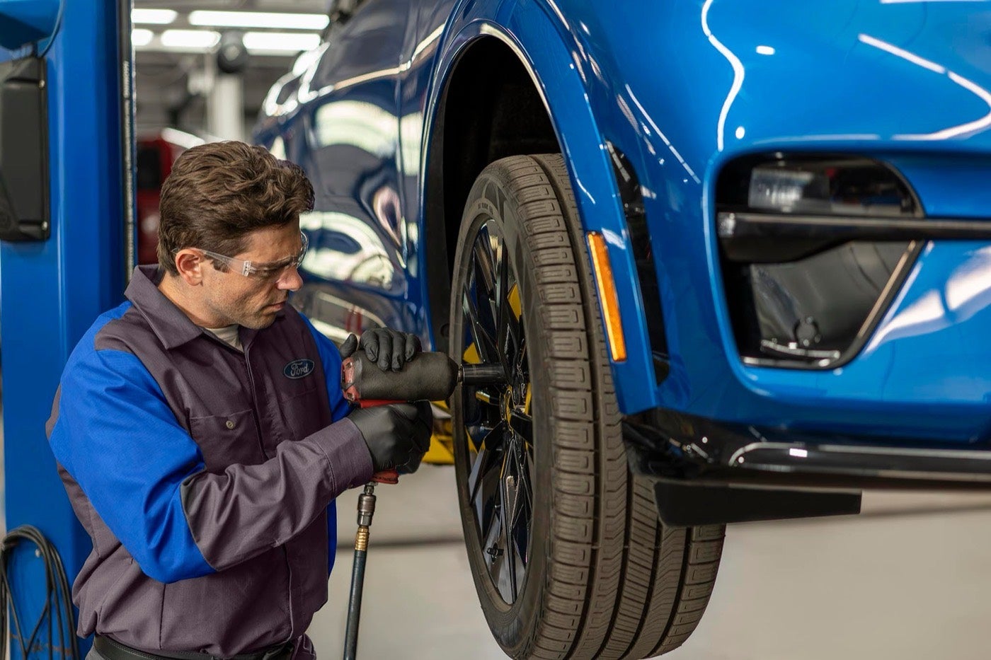 Ford Service technician tightening a wheel on a vehicle