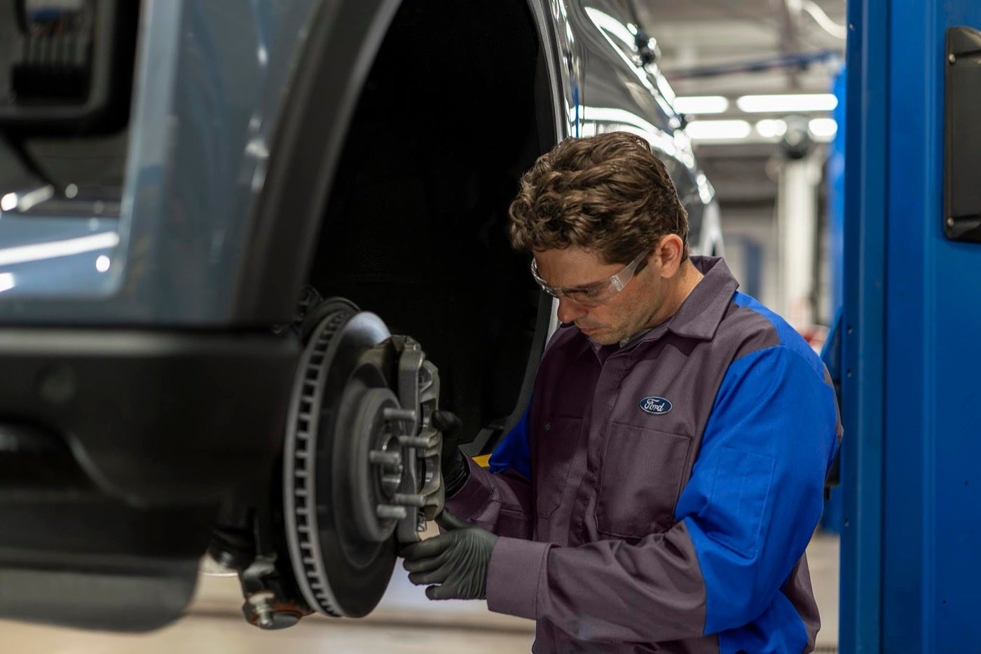 Ford Service technician inspecting a brake rotor and caliper