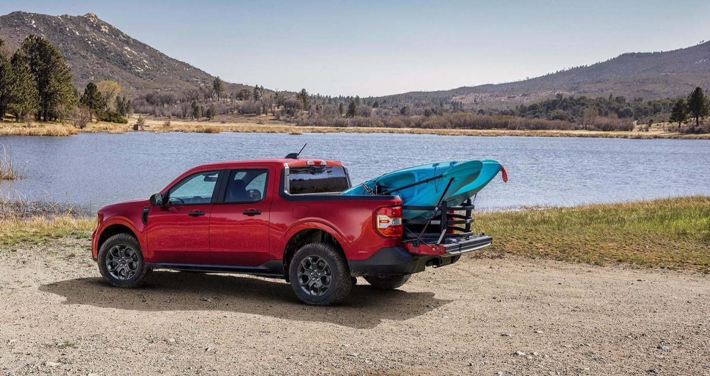 Ford Maverick Lariat parked near a lake with two kayaks in the bed