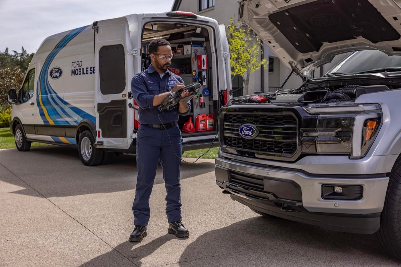 Ford Mobile Service technician performing a maintenance test on an F-150 in a customer driveway