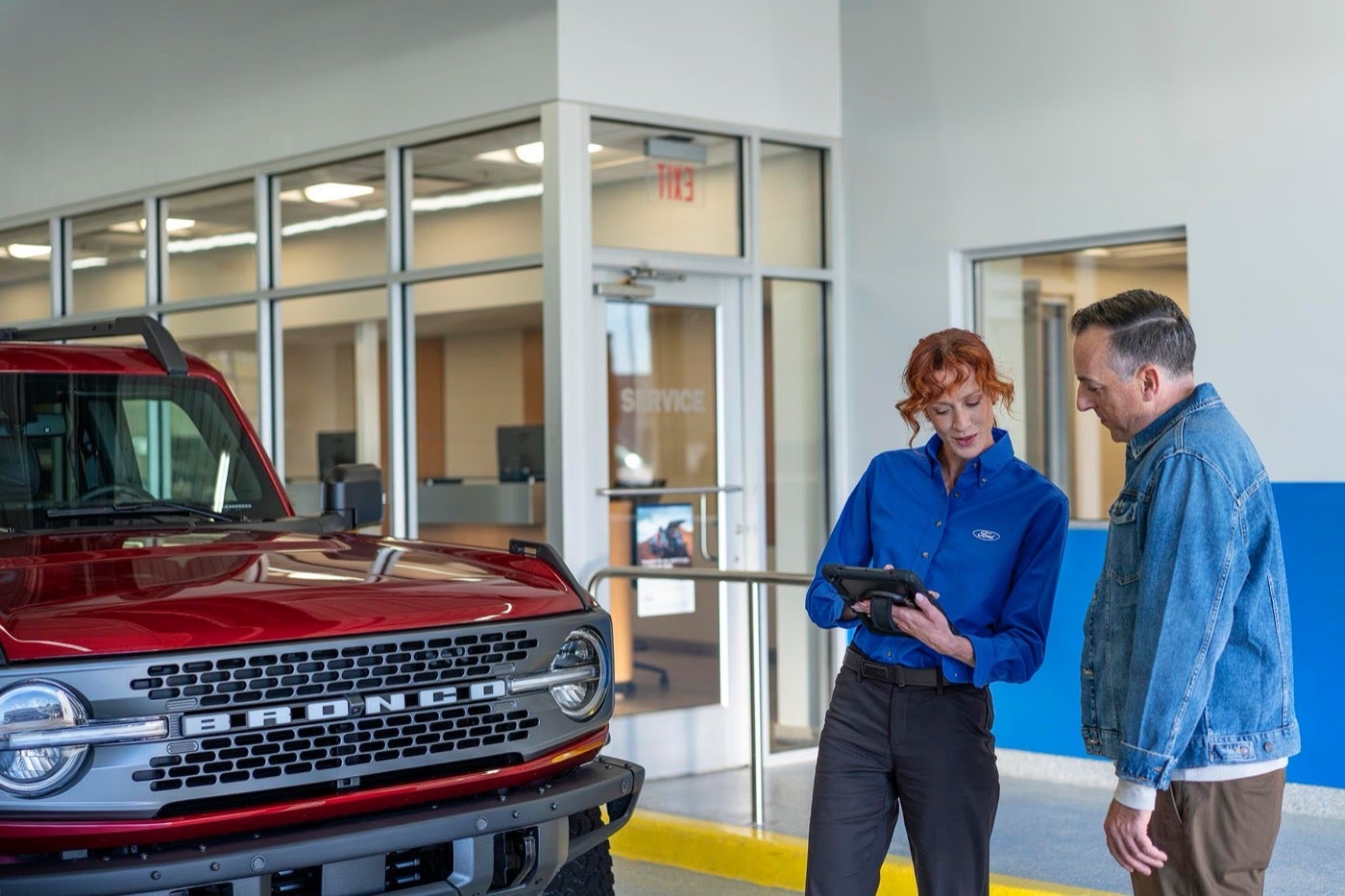 Ford Service representative and customer reviewing a maintenance schedule