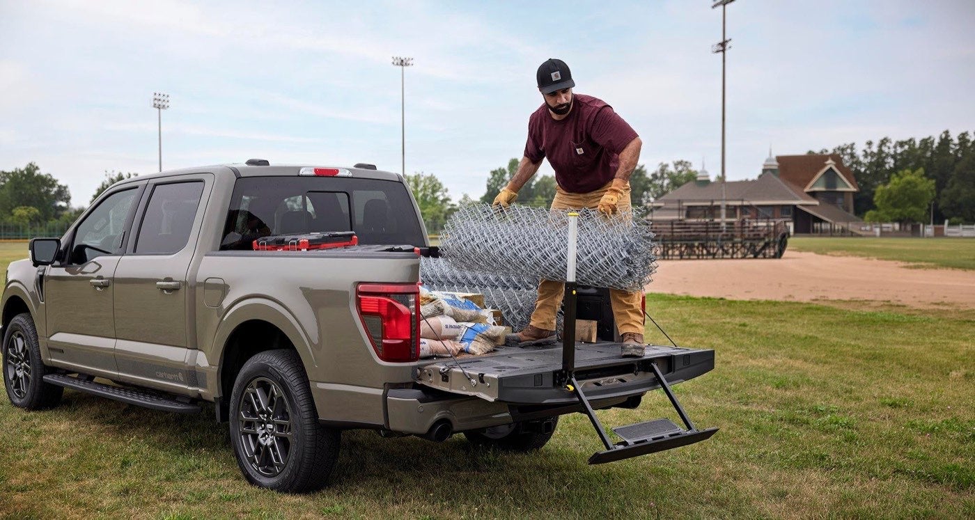 Man loading fencing into the bed of a Ford F-150 XLT