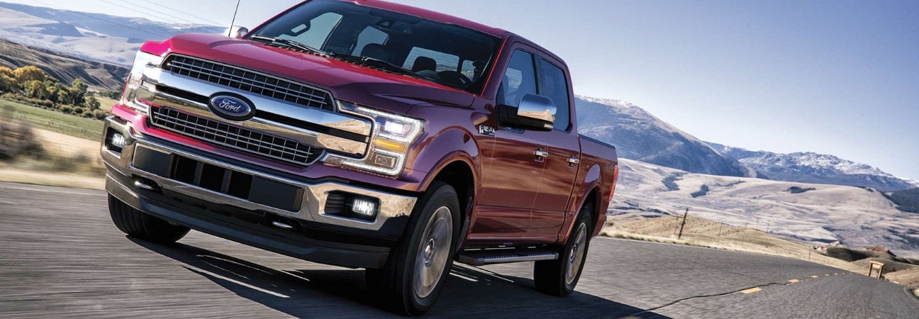 Red 2019 Ford F-150 cruising down mountain highway