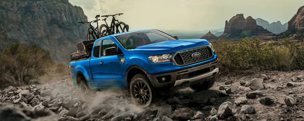 Blue Ford Ranger with bikes in truck bed