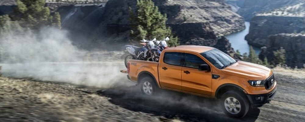 Orange Ford Ranger with dirt bikes in truck bed