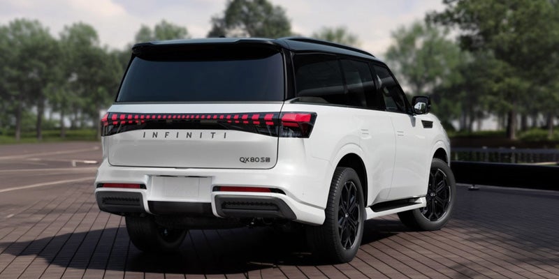 A white Infiniti QX80 SUV viewed from the rear, showcasing its sleek design and distinctive tail lights.