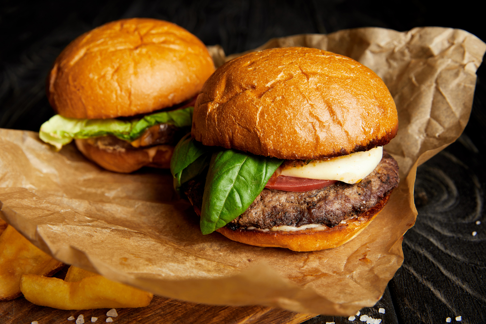 Two burgers on a piece of brown paper. | Burgers in Ellisville, MO