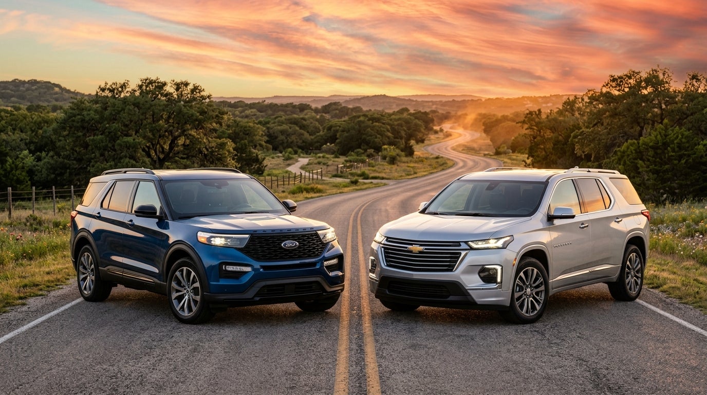 A blue Ford Explorer and a silver Chevrolet Traverse parked on a winding country road at sunset.