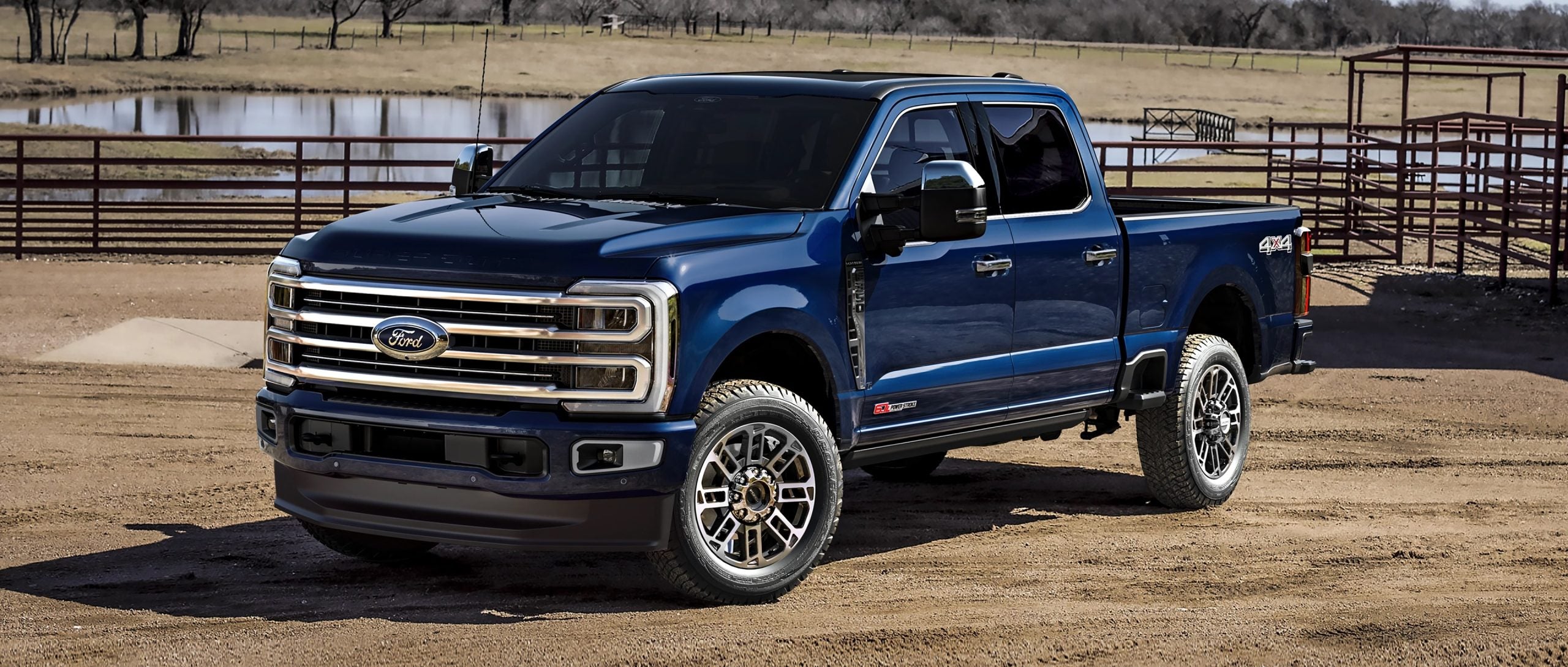 Blue 2025 Ford Super Duty parked in front of a lake